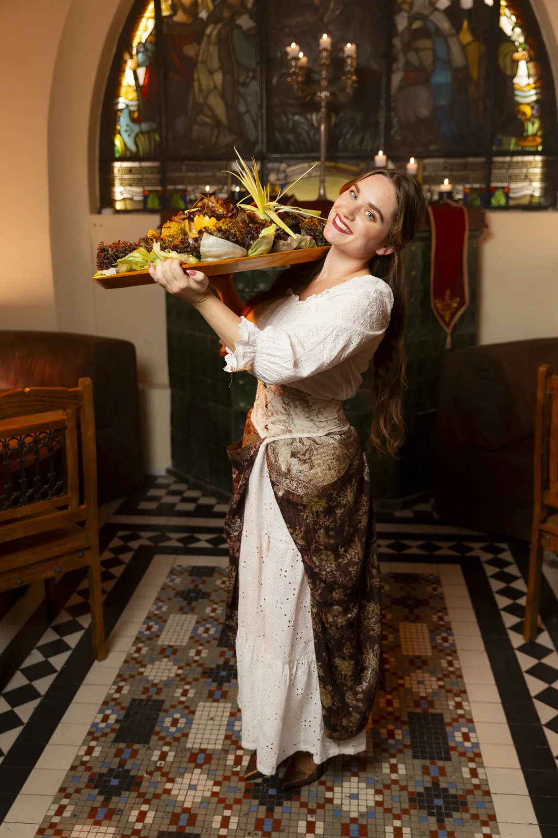 Waitress in medieval outfit bringing a platter of food during the dinner show at Apostolok