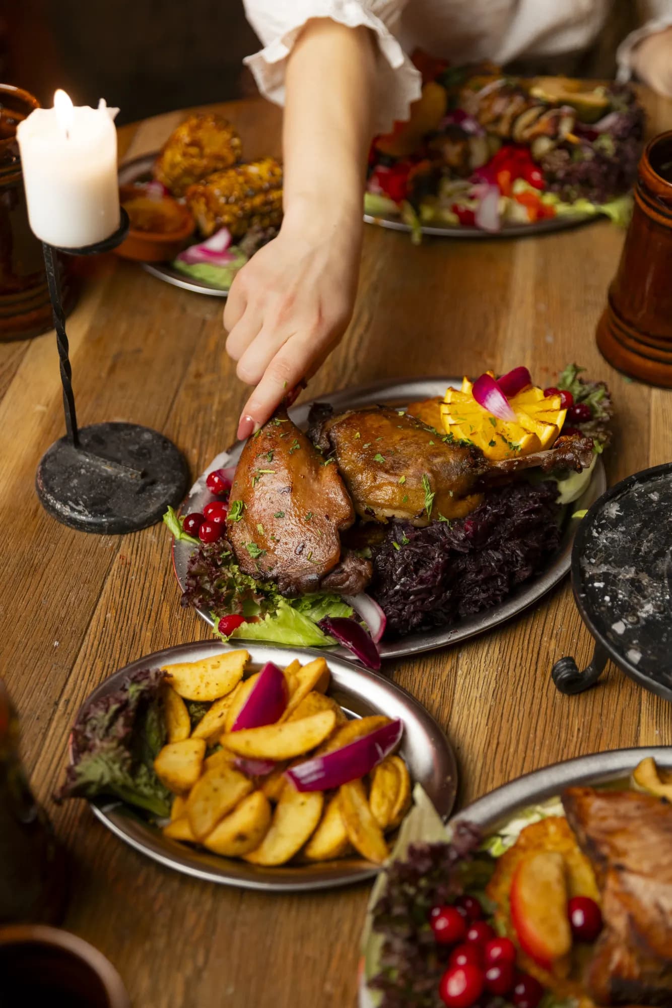 A hand taking a piece of food over a table.