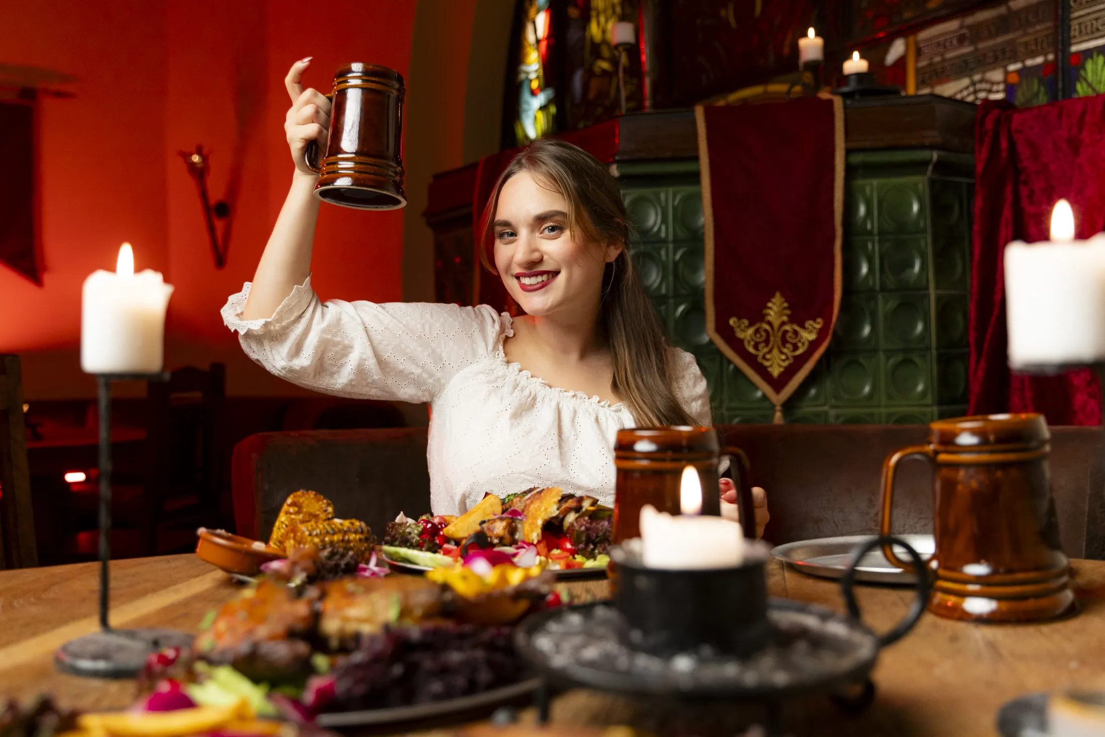 Beautiful woman doing a toast over a table full of food.